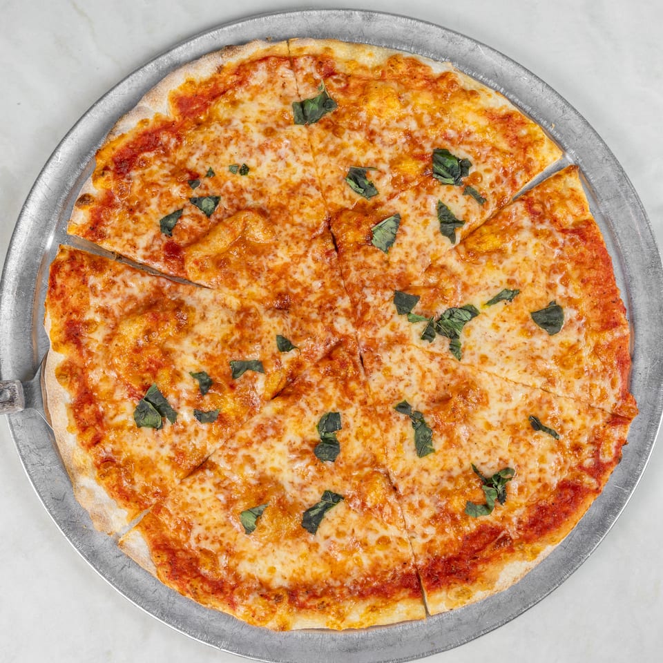 Large cheese pizza topped with tomato sauce and fresh basil, sliced on a round metal serving tray.
