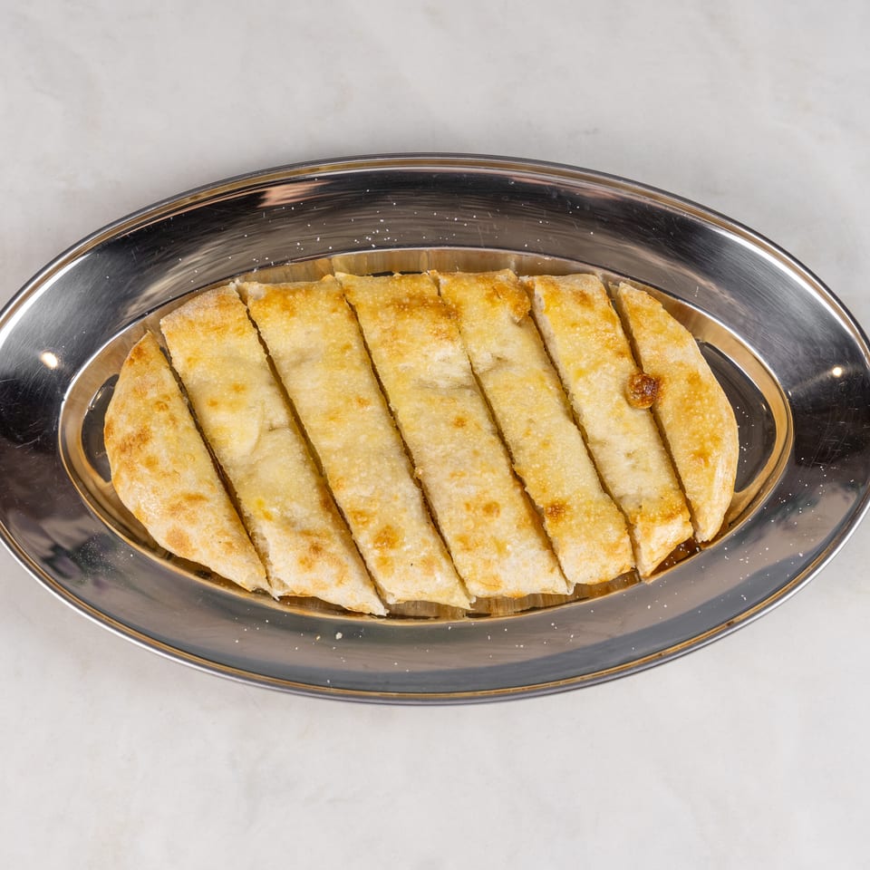 Golden-brown rectangular pastries arranged on a reflective oval serving platter.